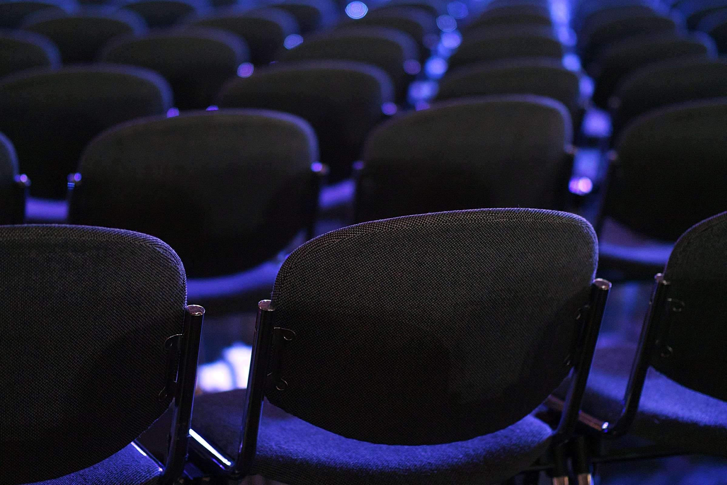 Empty chairs set out ready for a conference with blue lighting