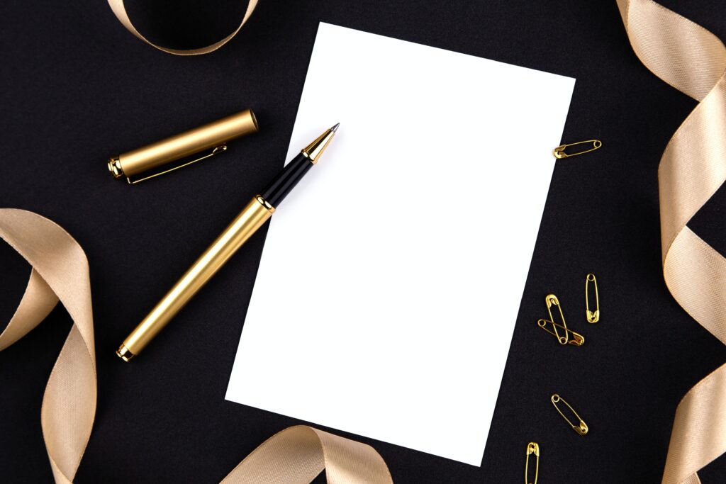 A blank piece of paper on a black table with an open fountain pen