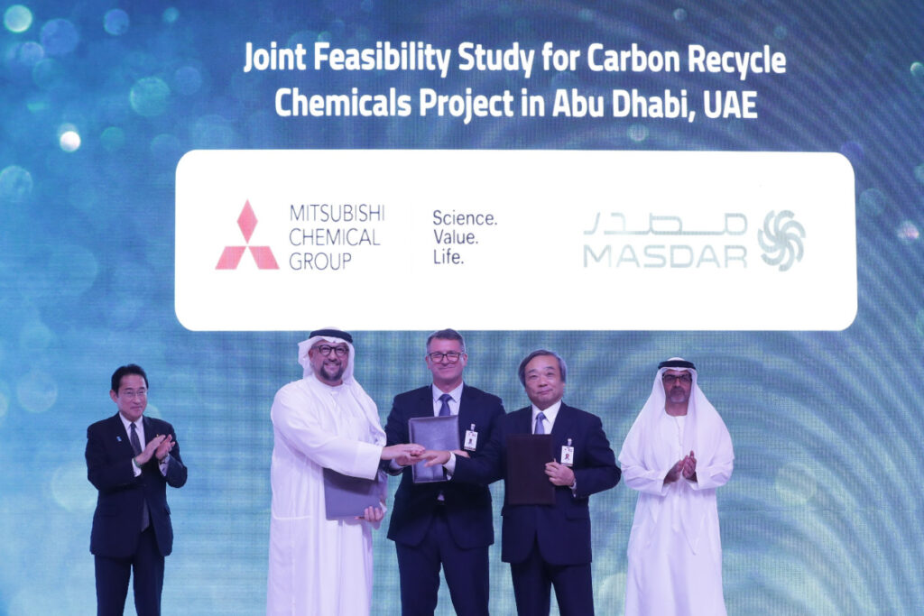 Five men in front of a screen shaking hands.