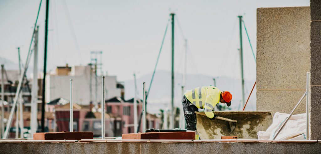 a person in a safety vest and hat working on a construction site