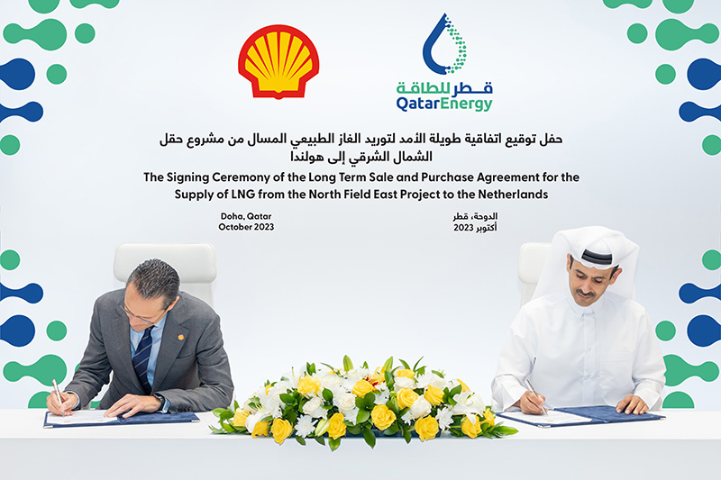 Two men sitting at a desk signing a contract