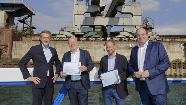 A group of men holding notebooks in front of port