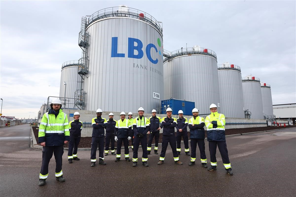 People in hi-vis in front of tanks