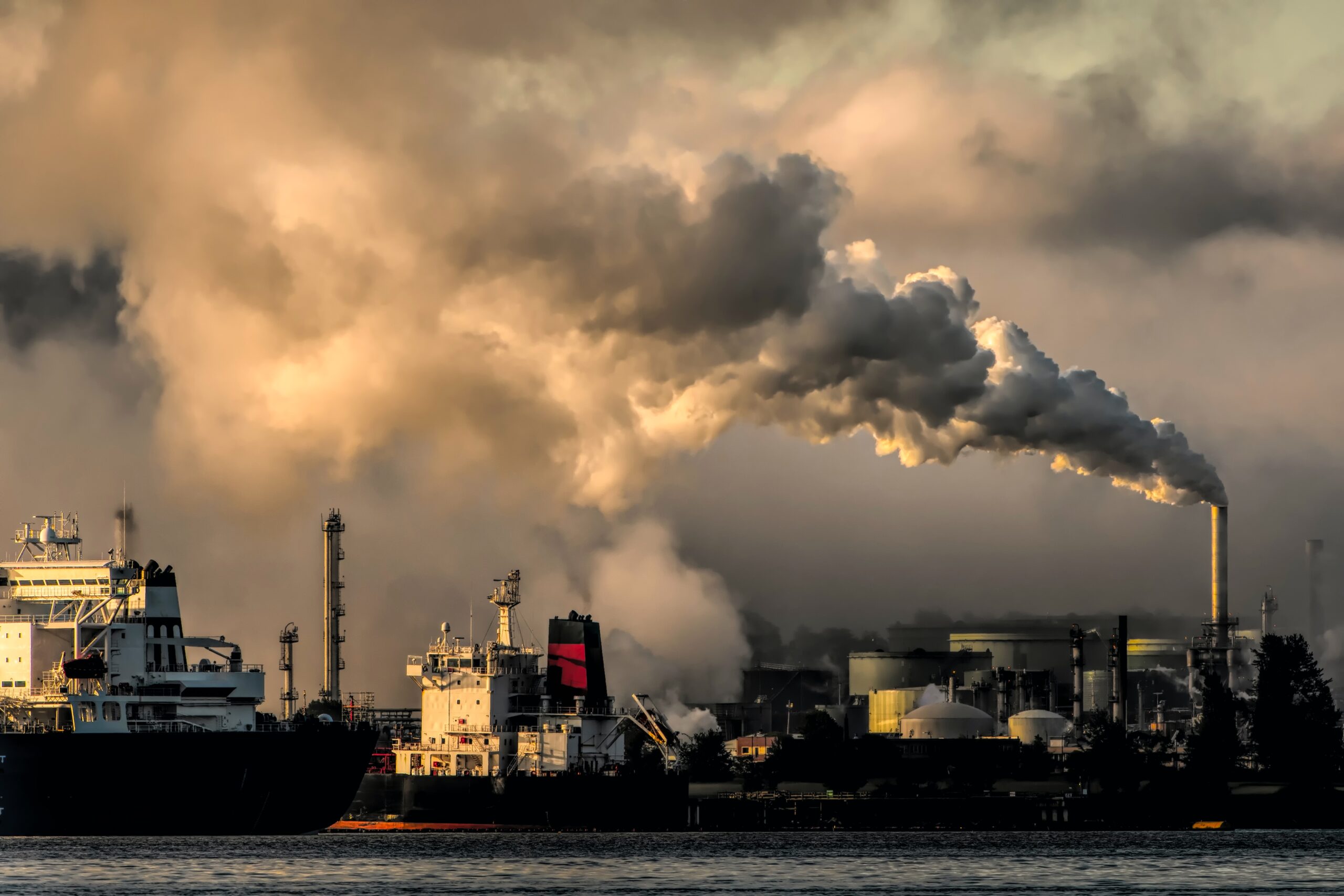 White and black ship on sea under smoke.